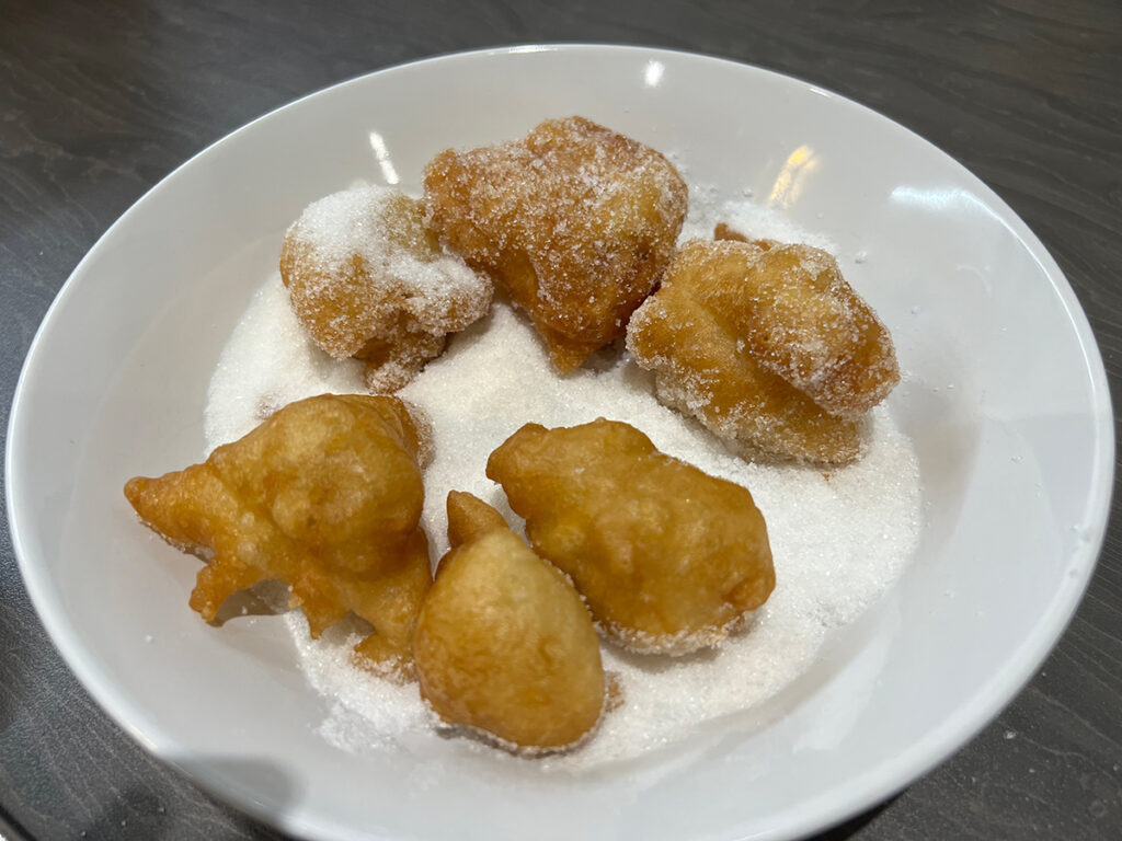 Roll your zeppole in sugar while still hot